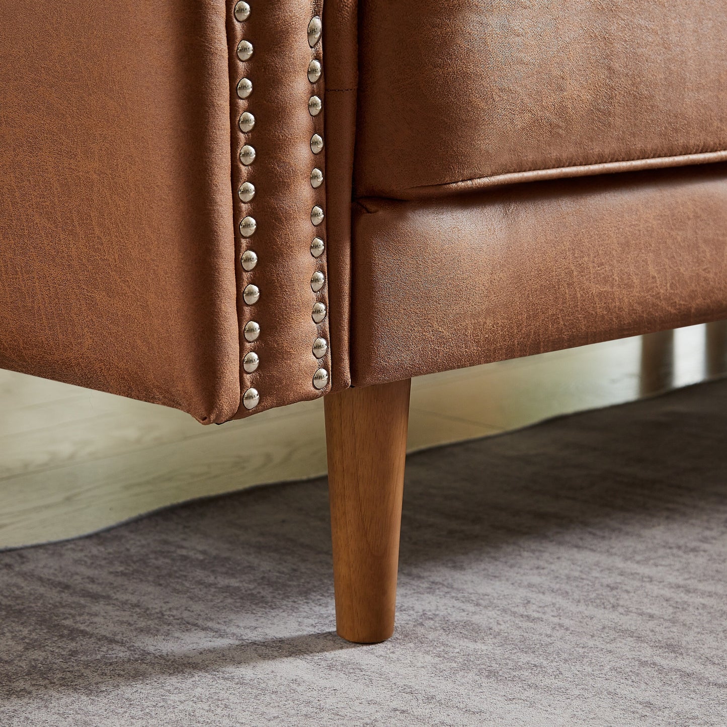 Canapé 3 places en cuir synthétique marron de 208 cm, forme L, avec méridienne gauche et clous décoratifs, finitions en cuivre et pieds en bois massif.