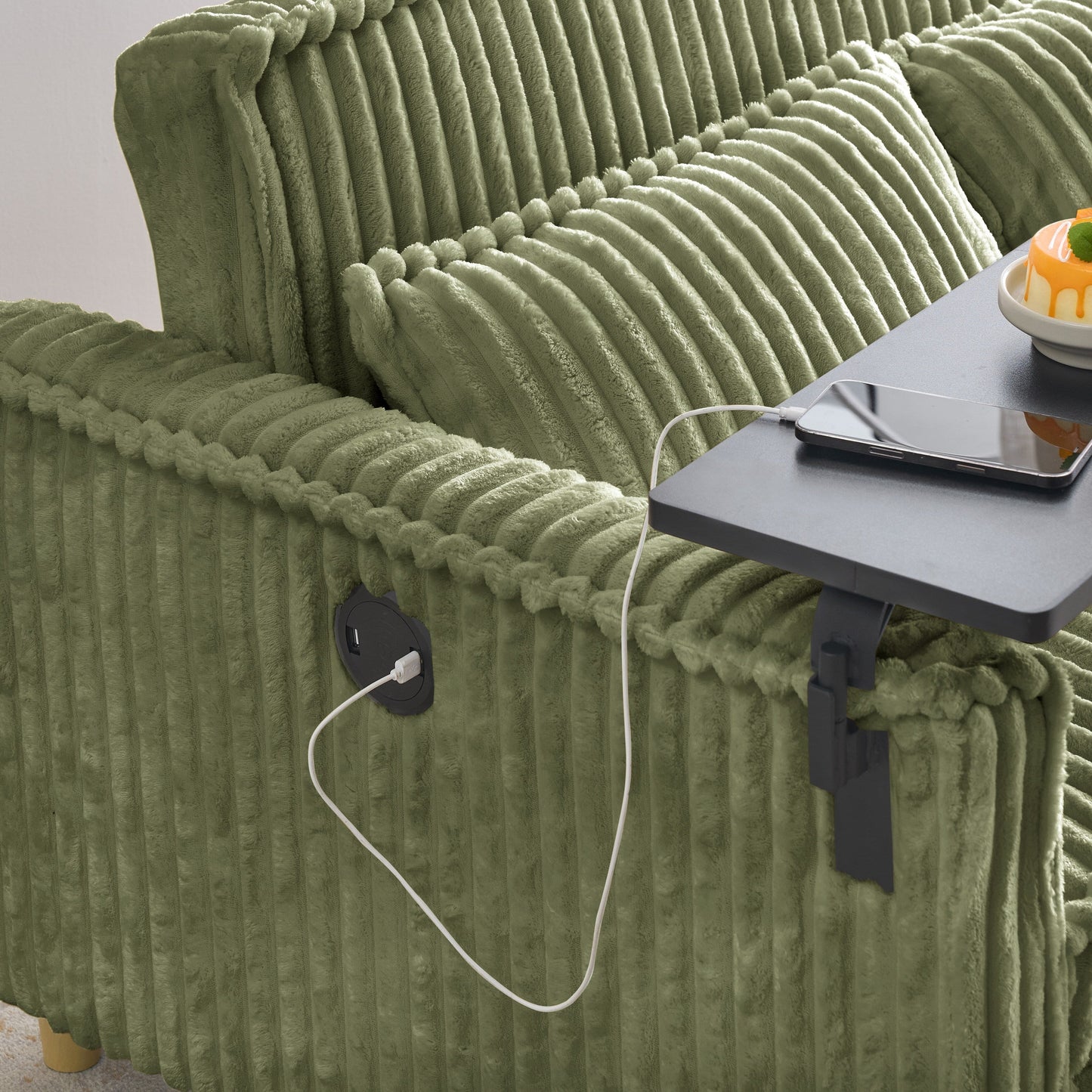 Le canapé en velours côtelé vert gigogne et rabattable à double fonction, équipé d'un plateau mobile et de ports USB